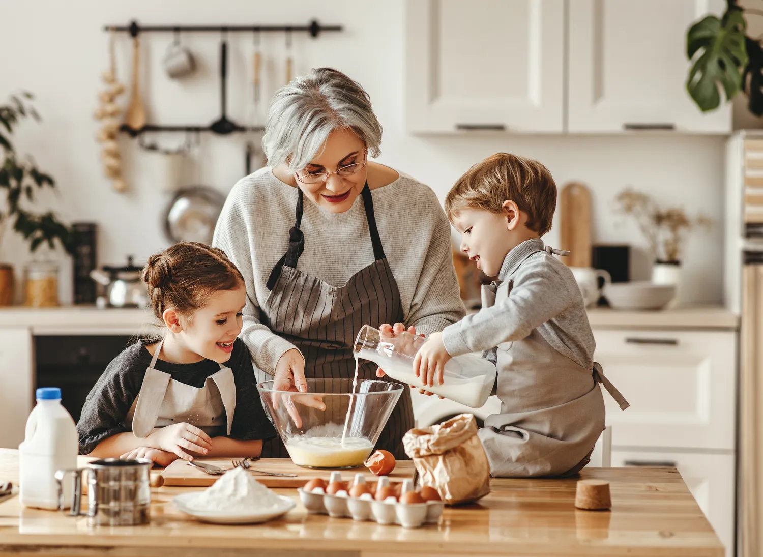 Senior lady spending time and cooking meals with young kids
